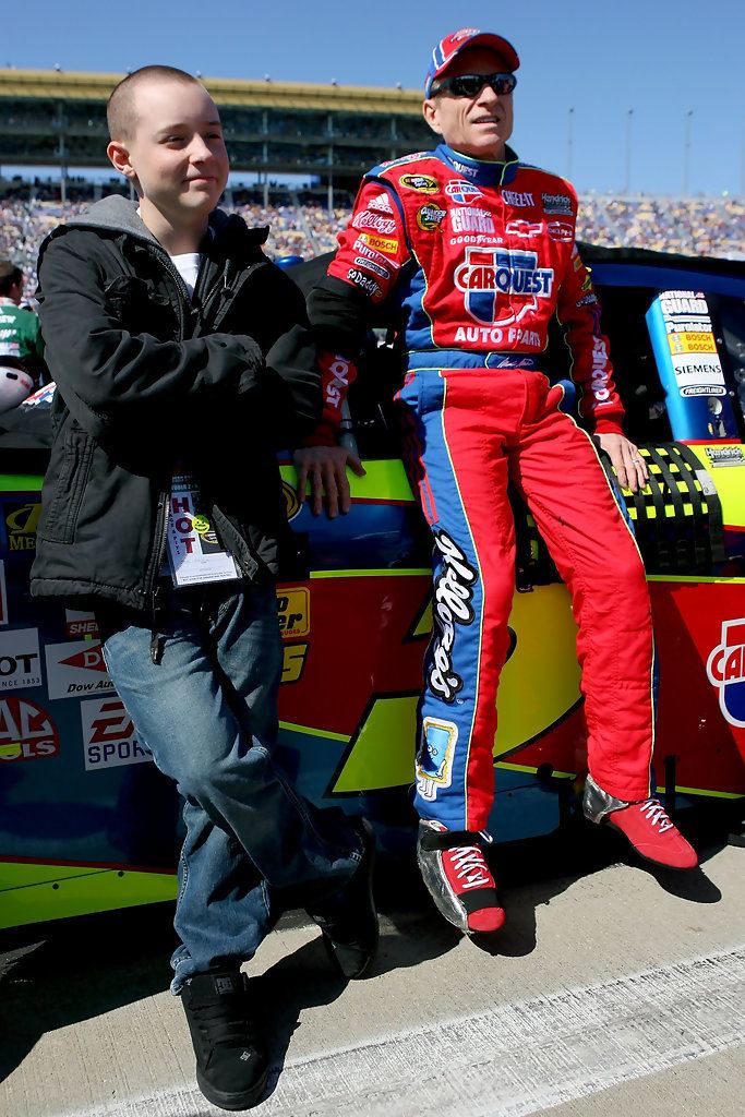 Matt Martin (racing driver) with his father Mark Martin sitting on the window frame wearing a red racing suit