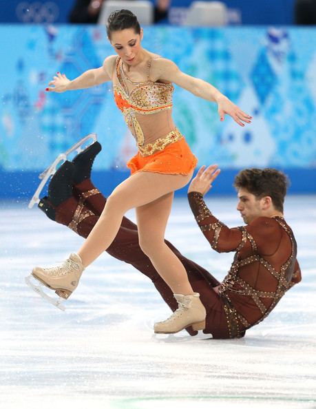 Matteo Guarise and Nicole Della Monica are dancing on the ice suddenly Matteo slip during the Figure Skating Pairs Short Program on day four of the Sochi 2014 Winter Olympics at Iceberg Skating Palace on February 11, 2014, in Sochi, Russia. Matteo is wearing brown pants, black skating shoes, brown see-through long sleeve under a brown vest while Nicole is wearing an orange and gold dress and beige skating shoes
