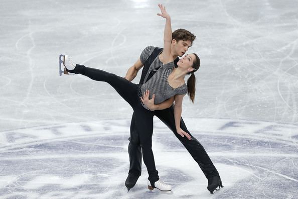 Nicole Della Monica and Matteo Guarise of Italy dancing on the ice in the Pairs Short Program during day two of the ISU Grand Prix of Figure Skating NHK Trophy at Sekisui Heim Super Arena in Rifu, Japan. Nicole is wearing a black and white blouse, black pants, and white skating shoes while Matteo is wearing black pants, black skating shoes, and a black and white shirt under a black vest