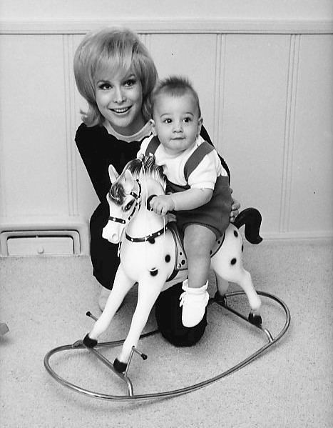 Barbara Eden with Matthew Ansara riding on a horse toy
