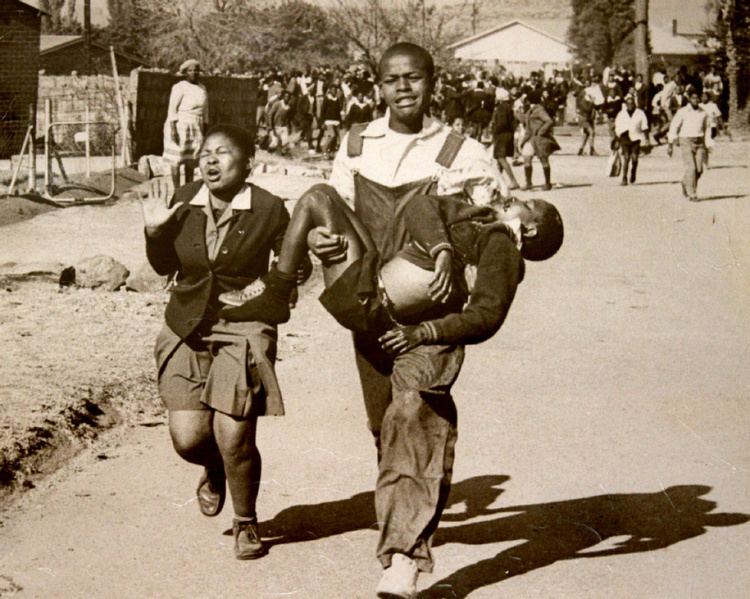 Hector Pieterson carried by Mbuyisa Makhubu after being shot by South African police. Peterson's sister, Antoinette runs beside them