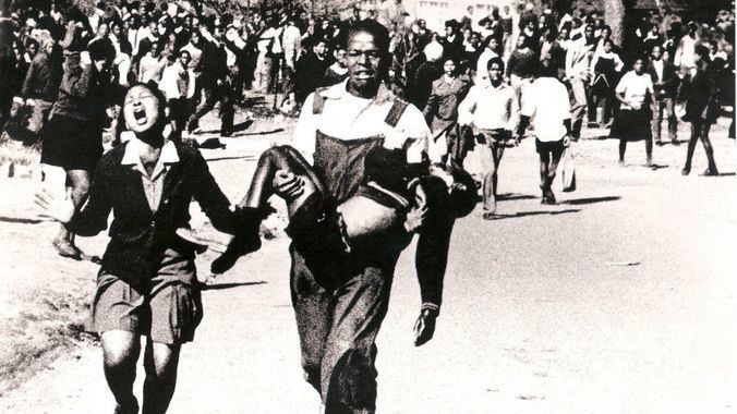 Hector Pieterson carried by Mbuyisa Makhubu after being shot by South African police. Peterson's sister, Antoinette runs beside them