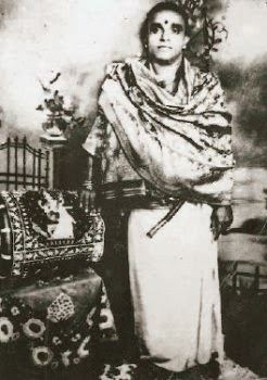 A younger Meenakshi Sundaram Pillai standing with a Bindi on the forehead and wearing religious robes.