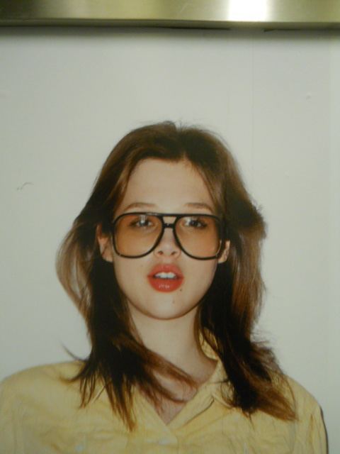 Megan Marshack at a young age, wearing glasses and a yellow shirt.