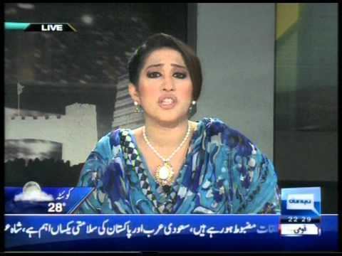 Meher Bukhari reporting the news while wearing a blue blouse, necklace, and earrings