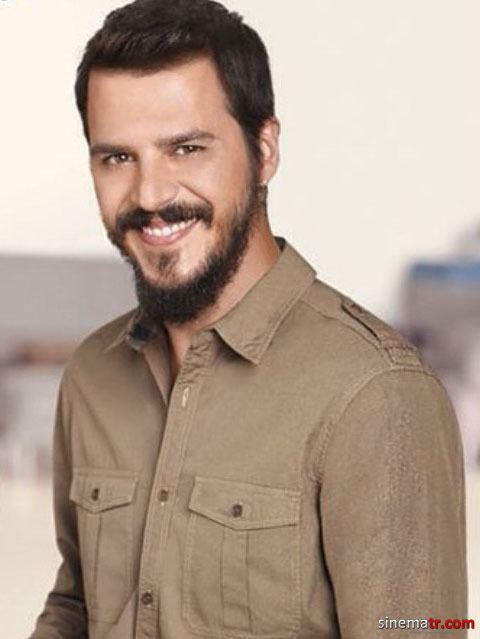 Mehmet Gunsur smiling with shorter hair and wearing a brown long-sleeved casual shirt.