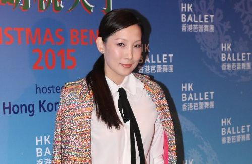 Melissa Ng is smiling, has black straight hair, wearing an earring and a white polo with a black necktie and a colorful coat during the promotional event.
