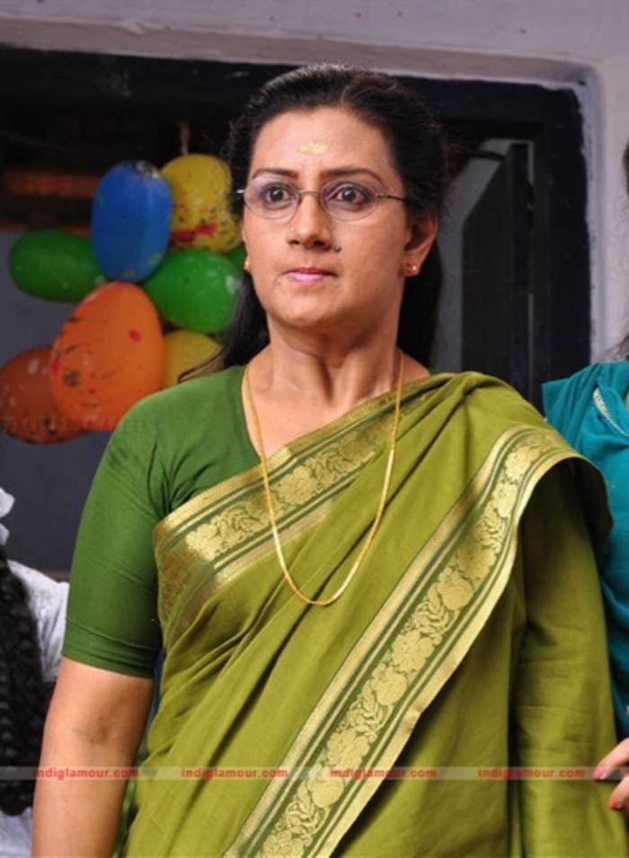 Menaka (actress) wearing a green dress, pair of eyeglasses, and a gold necklace