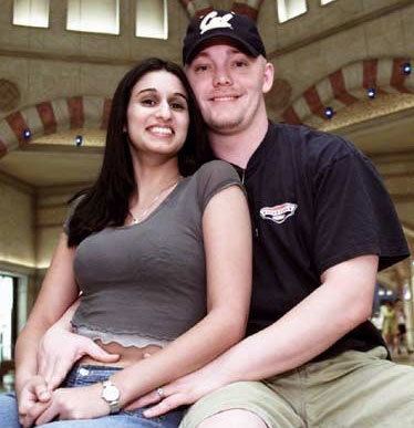 Meriam Al-Khalifa smiling while Jason Johnson hugging her and he is wearing a black t-shirt and khaki shorts