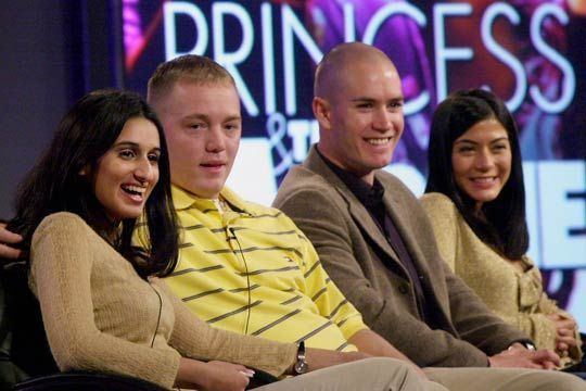 Meriam Al-Khalifa laughing and sitting on the couch with Jason Johnson and two other people while she is wearing a brown long sleeve blouse