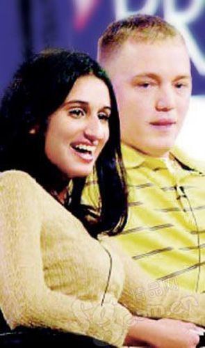 Meriam Al-Khalifa laughing and looking at something while Jason Johnson is beside her and wearing a yellow striped polo shirt
