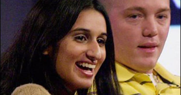 Meriam Al-Khalifa laughing and looking at something while Jason Johnson is beside her and wearing a yellow striped polo shirt