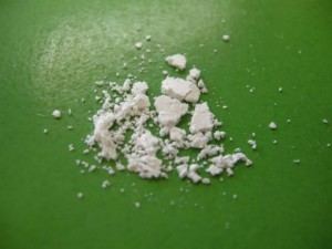 A white crystalline powder called Methcathinone on a green table.