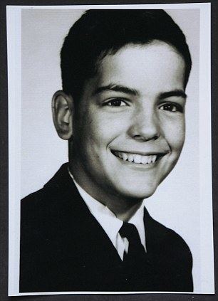 Michael A. Hess at a young age, wearing a black suit and a tie.