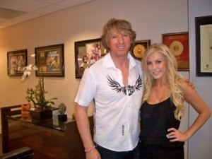 Michael Blakey smiling while posing with Crystal Harris and wearing a white buttoned polo shirt.