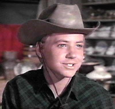 Michael Burns smiling while wearing a green shirt and a brown hat