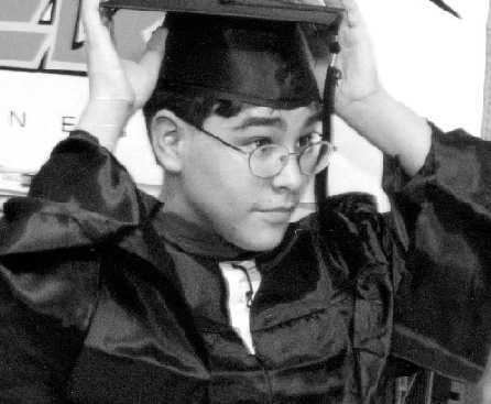 Michael Kearney holding his square academic cap