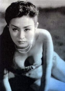 Michiko Maeda with a fierce look while wearing a necklace and a tube top showing her cleavage