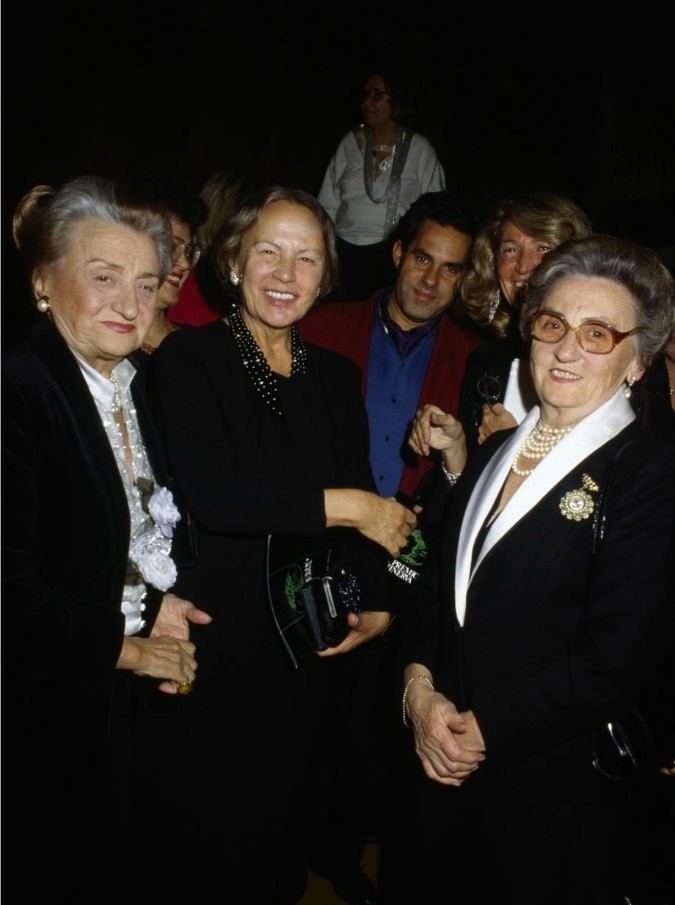Micol Fontana posing with a group of people in a formal event.