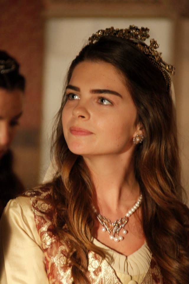 Pelin Karahan as Mihrimah Sultan wearing a beige and brown gown, a crown, and necklace in the 2011 tv series, The Magnificent Century