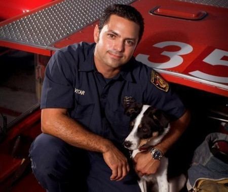 Michael Anthony Vitar on his blue uniform with a dog.