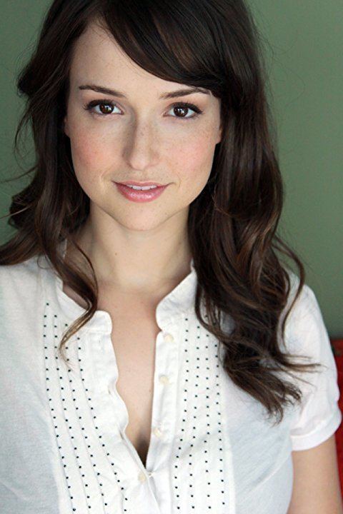 Milana Vayntrub smiles while wearing a white shirt