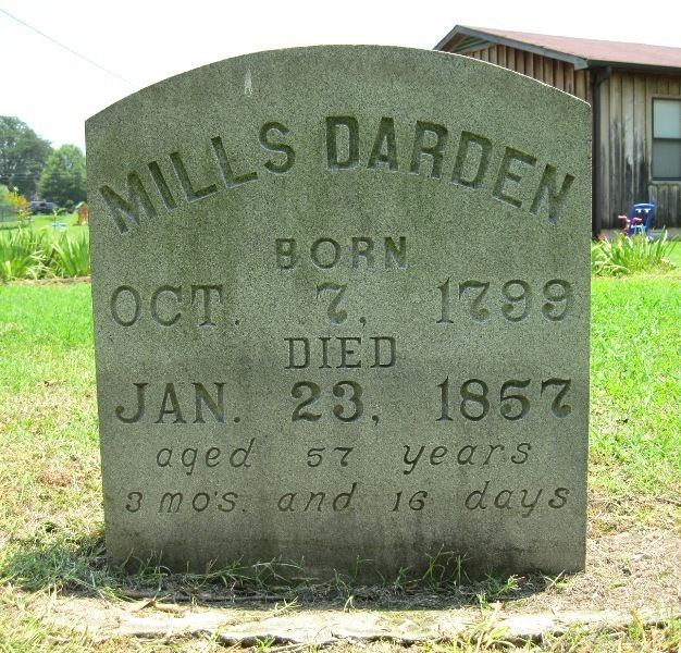 A marble tombstone of Mills Darden with his name carved on it and additional details like "BORN on OCT 7, 1799 and DIED on Jan 23, 1857, aged 57 years 3 mos and 16 days"