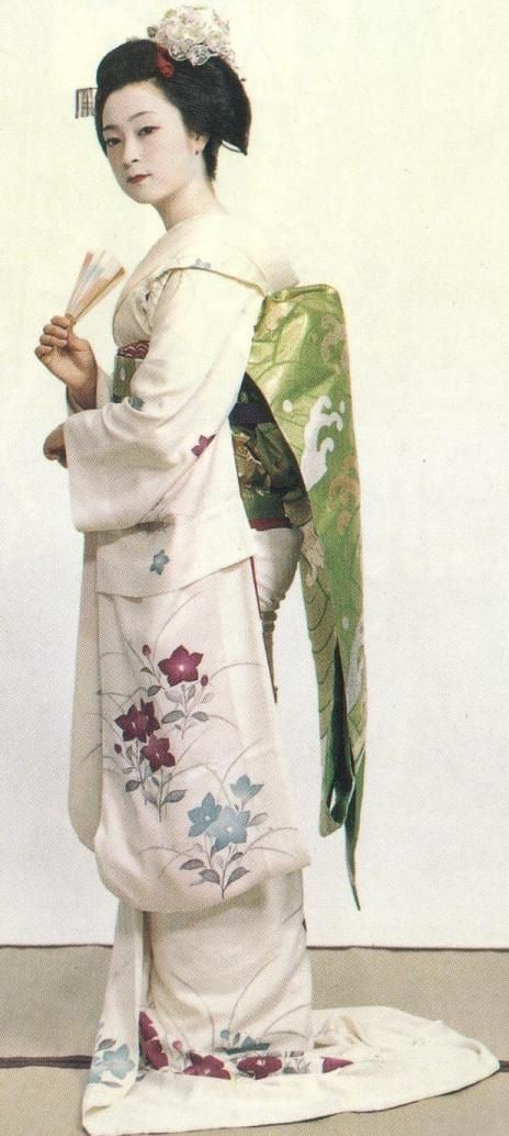 Mineko Iwasaki wearing floral kimono while holding a hand fan