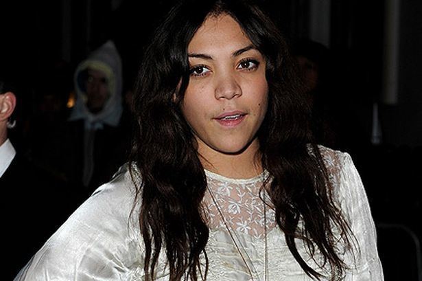 Miquita Oliver com cabelo encaracolado, enquanto vestindo o vestido branco