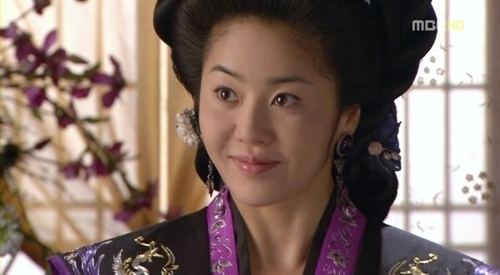 Go Hyun-jung as Lady Mishil smiling while wearing a black and violet kimono in a scene from the 2009 historical drama Queen Seondeok