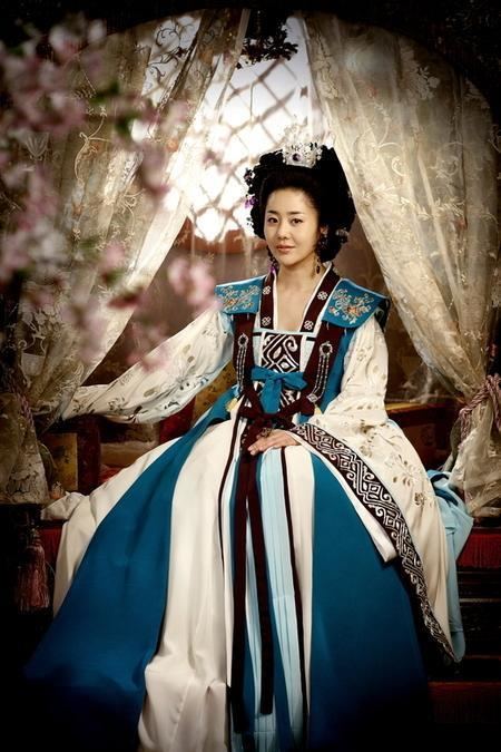 Go Hyun-jung as Lady Mishil smiling while wearing a brown, white and blue kimono in a scene from the 2009 historical drama Queen Seondeok