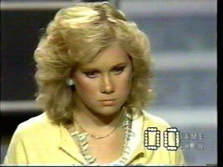 Missy Gold in a TV show wearing a yellow dress.