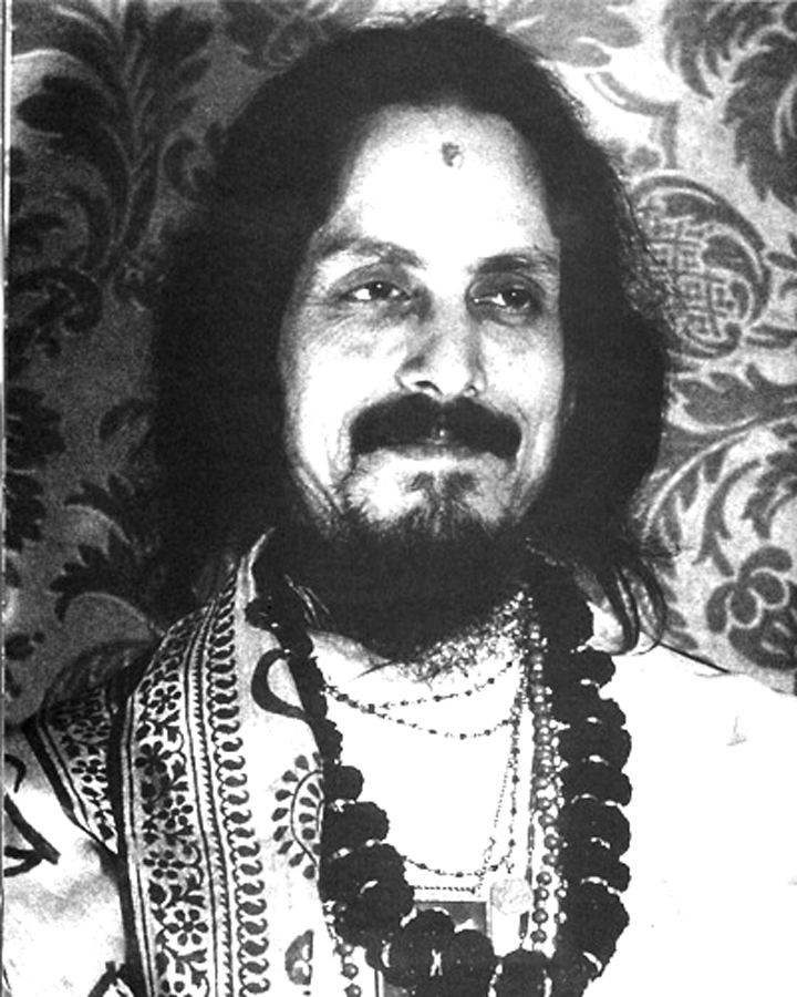 Mohanananda Brahmachari smiling with mustache and beard while wearing necklace, shawl, and dress