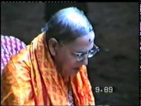 Mohanananda Brahmachari looking at something while wearing an orange shawl and eyeglasses