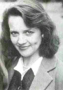 Moira Brooker with wavy hair and smiling.