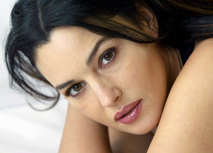 Monica Bellucci's headshot with black curly hair and pink lipstick