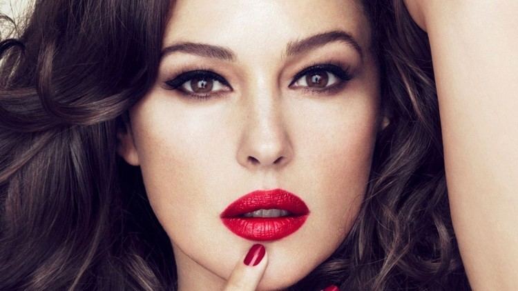 Monica Bellucci's headshot while hand on her chin and wearing a red lipstick