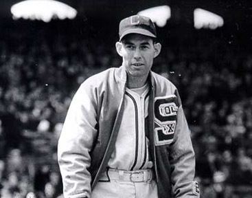 Monty Stratton standing in the middle of the stadium while wearing a jacket, cap, long sleeves, belt, and pants