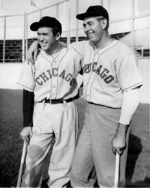 James Stewart and Chicago White Sox pitcher Monty Stratton smiling together while looking afar and holding a baseball stick