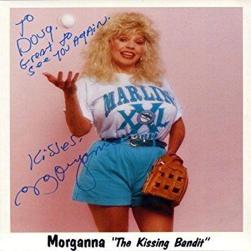 Poster of Morganna with autograph, wearing a white shirt, blue shorts, and gloves.