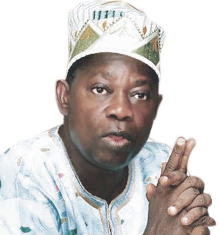 Moshood Abiola in his Nigerian outfit while pointing his finger up