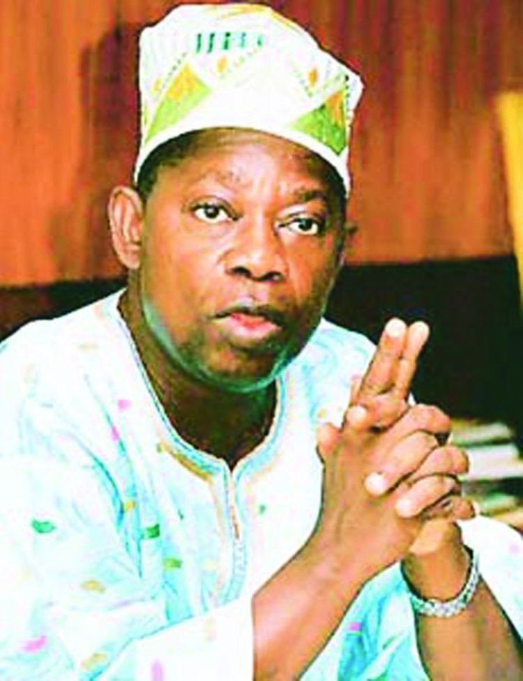 Moshood Abiola in his Nigerian outfit while pointing his finger up