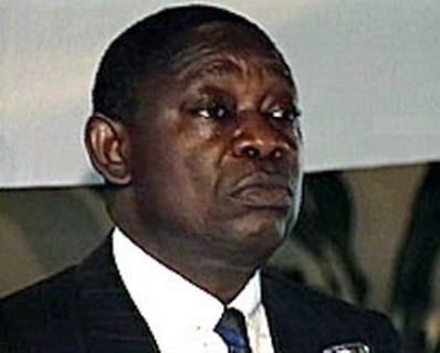 Moshood Abiola wearing a black coat and white long sleeves