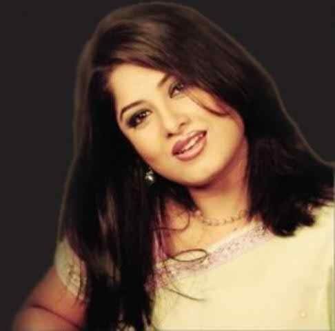 Moushumi smiling while wearing a cream blouse, necklace, and earrings