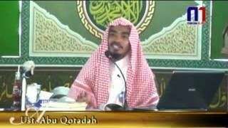 News featuring Muqbil bin Hadi al-Wadi'i wearing hijab with a microphone in front of him.