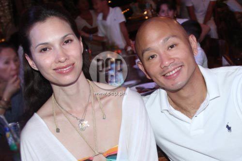 Nanette Medved with her husband Chris Po in a party in Boracay Island wearing a white dress and a necklace.