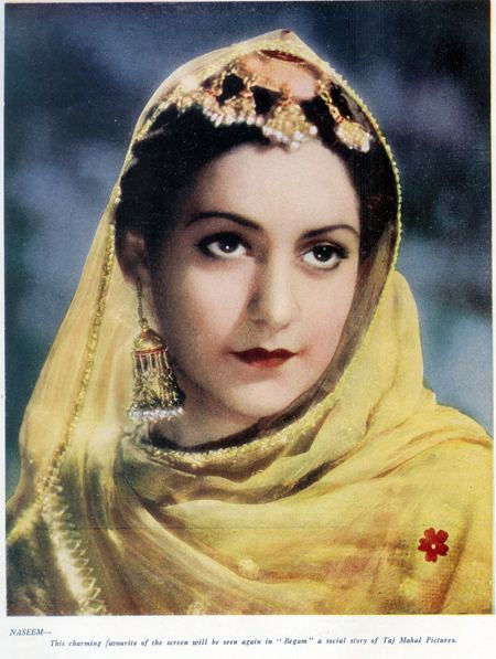 Naseem Banu with a serious face, wearing a yellow dupatta scarf, and earrings.