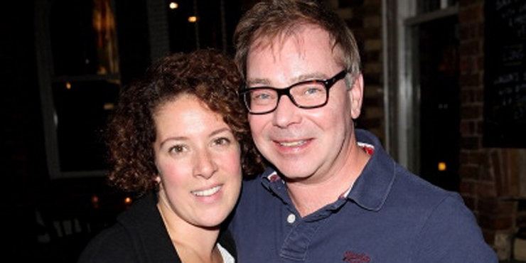 Natalie Casey smiling and with curly short hair while her husband Paul Kemp wearing eyeglasses and a blue polo shirt.