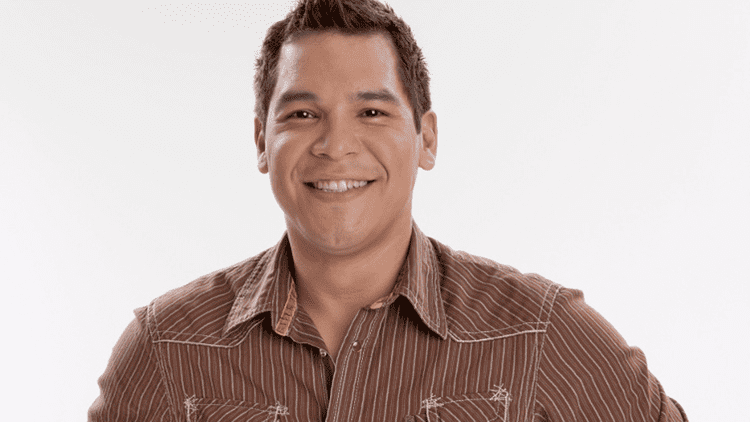 Smiling Nathaniel Arcand in a white background