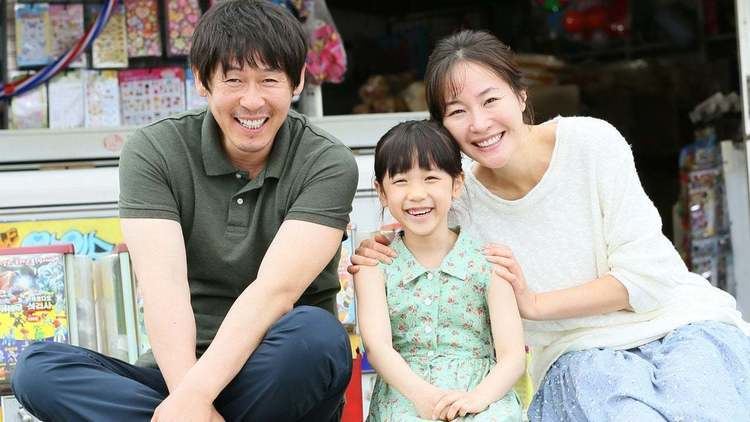 Sol Kyung-gu, Uhm Ji-won, and Lee Re smiling and sitting together in a scene from the 2013 film "Hope" based on the story of Nayoung's case